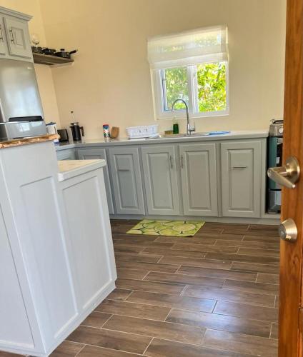 a kitchen with white cabinets and a wooden floor at Kaye Devo in Choiseul