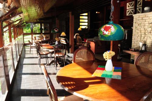 a wooden table with chairs and a vase on it at Hotel Daniela in Penedo