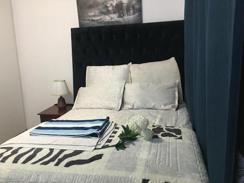 um quarto com uma cama com uma cabeceira preta em Lovely Room In a Shared Apartment with Pool em Joanesburgo