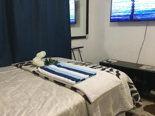 uma cama com uma toalha e um ursinho de peluche em Lovely Room In a Shared Apartment with Pool em Joanesburgo