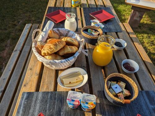 - une table de pique-nique avec un panier de pain et des bouteilles de jus d'orange dans l'établissement LE CEDRE BLEU, à Saint-Michel-sur-Meurthe