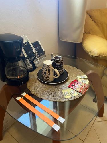 une table en verre avec deux tasses à café en haut dans l'établissement Caribbean Queen, à Cancún