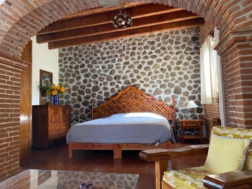 a bedroom with a bed and a brick wall at Linda Villa al lado del Club de Tenis in Cuernavaca