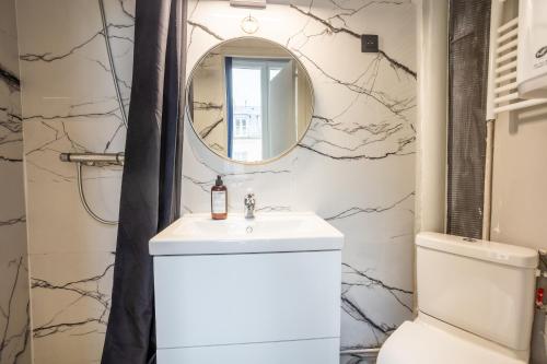 a bathroom with a sink and a mirror at Bail Mobilite Luxe Le Marais in Paris