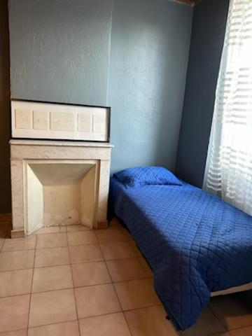 une chambre avec un lit et une cheminée dans l'établissement Grand Studio 3 personnes Marseille, à Marseille