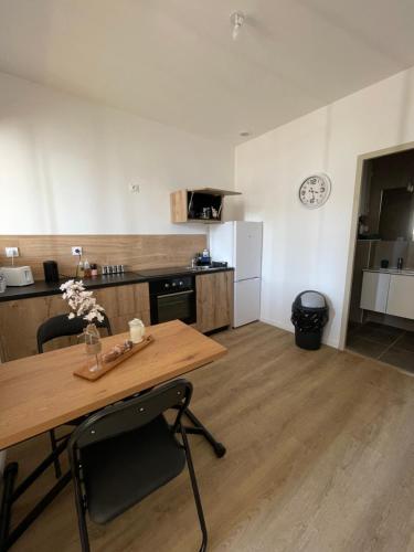 eine Küche mit einem Holztisch sowie einem Tisch und Stühlen in der Unterkunft Studio Design - Terrasse - Proche du stade in Saint-Étienne