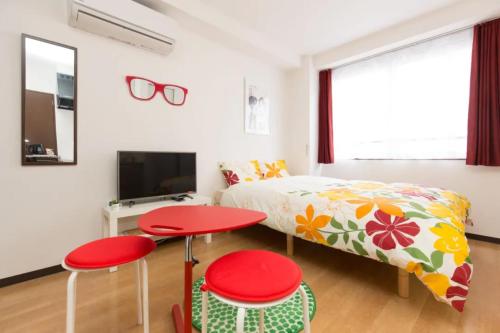 a bedroom with a bed and two red tables at Hotel Lucky in Osaka