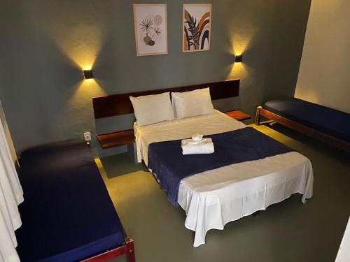 a bedroom with a bed with a blue and white blanket at Pousada Puerta Del Sol Rio das Ostras in Rio das Ostras