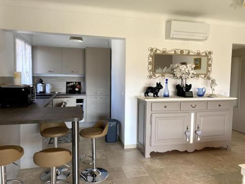 una cucina con bancone e sgabelli in una stanza di Agréable appartement vue mer a Les Issambres