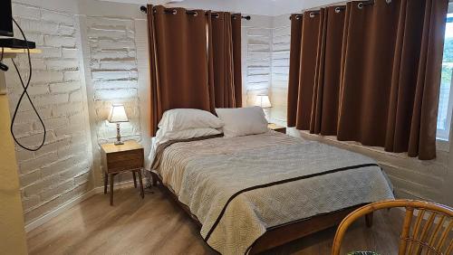 um pequeno quarto com uma cama e uma janela em Little European Lodge em Carmel Valley