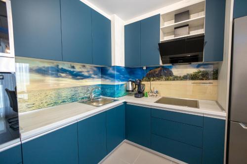 a kitchen with blue cabinets and a sink at 16th Floor Sky View Condo With Pool And Fitness in Skopje