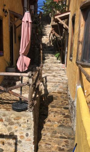 a pink umbrella sitting on the side of a street at Hotel Quinto Sol in Mazunte