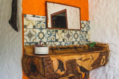 y baño con lavabo de madera y espejo. en Selvatica EcoHostal, en San Carlos