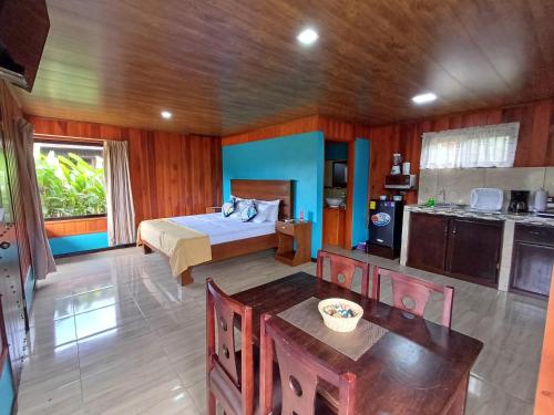 ein Schlafzimmer mit einem Bett und einer Küche darin in der Unterkunft Cabañas Sueños del Arenal in Fortuna