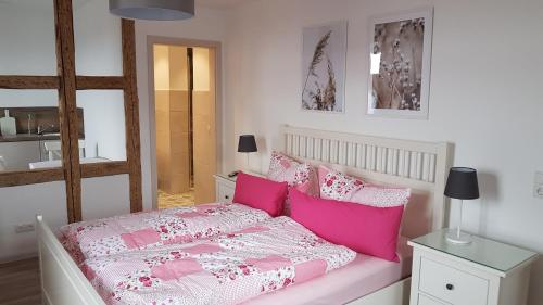 a bedroom with a pink bed with pink pillows at Ferienwohnung Kaffestübchen 