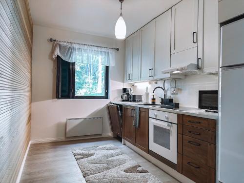 eine Küche mit weißen Schränken und einem Fenster in der Unterkunft Sapelin airbnb, Parkano in Parkano