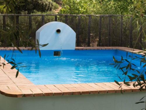 una piscina con una fuente de agua en un patio trasero en Ranchito de Alhucemas,piscina privada y barbacoa, en Montellano