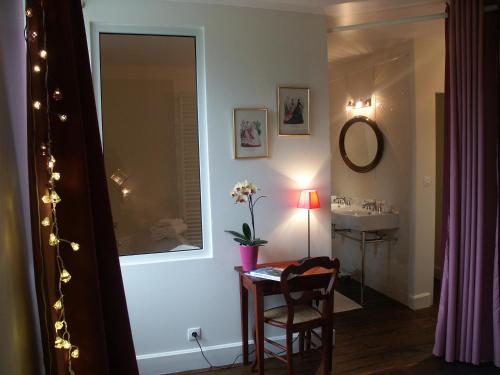 a bathroom with a sink and a table with a mirror at Chambres d'hôtes -B&B- La Bonneterie in Montaigut-le-Blanc