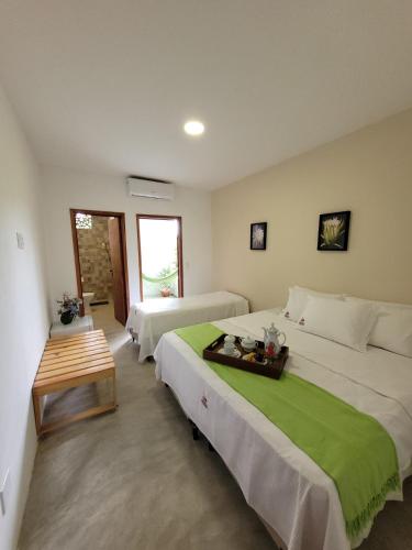 a bedroom with two beds and a table in it at Pousada Prazeres do Velho Chico in Belo Monte