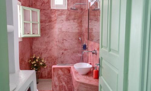 een badkamer met een wastafel en een rode muur bij Mythos Traditional Stonehouse in Kamari