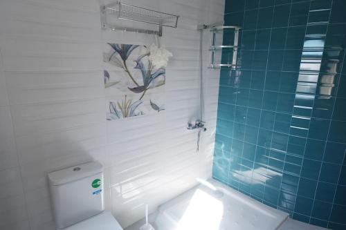 ein Badezimmer mit einem WC und einer blau gefliesten Wand in der Unterkunft Villa vue sur mer avec piscine in Tangier