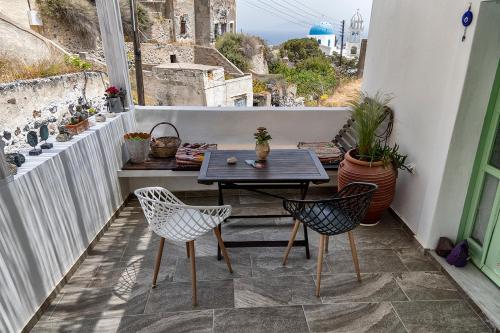 a patio with a table and chairs on a balcony at Mythos Traditional Stonehouse in Kamari