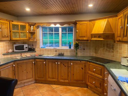a kitchen with wooden cabinets and a window at Spacious Countryside 5BD House! in Cavan