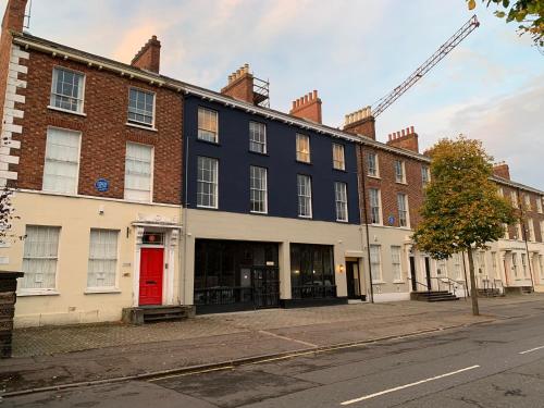 un grand bâtiment avec une porte rouge dans une rue dans l'établissement The Auction House, à Belfast