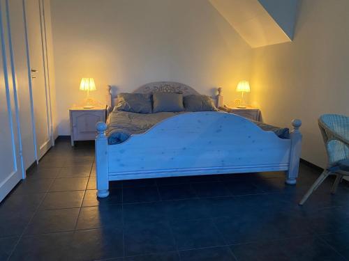 łóżko w pokoju z dwoma stołami i dwoma lampami w obiekcie Skedala horsefarm w mieście Halmstad