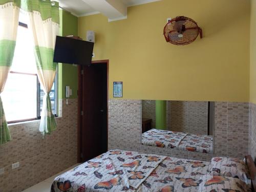 a bedroom with two beds and a tv on the wall at Luz de Luna in Piura