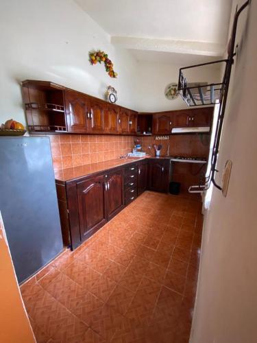Il comprend une cuisine avec des placards en bois et du carrelage. dans l'établissement Casa guayacan, à Palenque