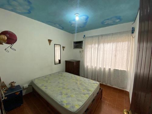 1 dormitorio con 1 cama en una habitación con ventana en Casa guayacan, en Palenque