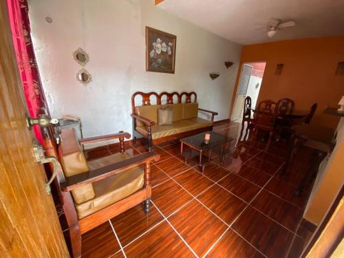 sala de estar con suelo de madera, mesa y sillas en Casa guayacan, en Palenque