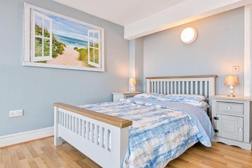 a bedroom with a bed and a picture of a beach at Let's go sea in Swansea