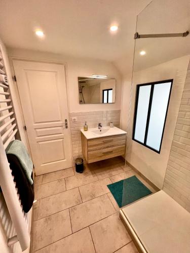 une salle de bain avec un lavabo et un miroir dans l'établissement Sweet Abreuvoir, à Saint-Germain-en-Laye