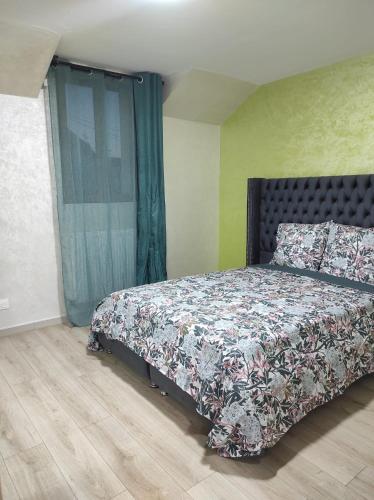 une chambre avec un lit avec un couvre-lit fleuri dans l'établissement Maison élégante et spacieuse, à Écouen