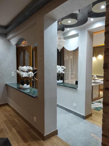 - un salon avec un lustre et un miroir dans l'établissement Maison élégante et spacieuse, à Écouen