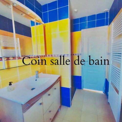 La salle de bains est pourvue d'un lavabo et d'un mur jaune et bleu. dans l'établissement l'aVentoux're, à Caromb