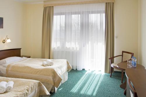 a hotel room with two beds and a window at Hotel Zieleniec in Zieleniec