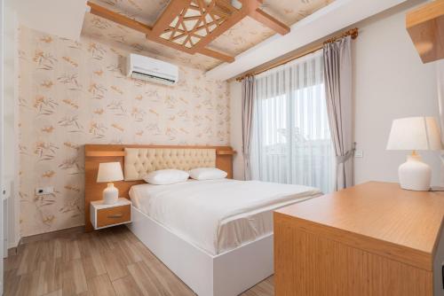 1 dormitorio con cama blanca y ventana en Loi Suite, en Antalya