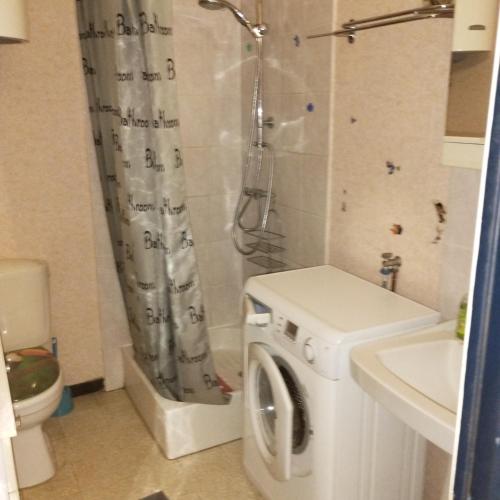 een badkamer met een wasmachine en een douche bij Appartement T2 près de la mer in Canet-en-Roussillon