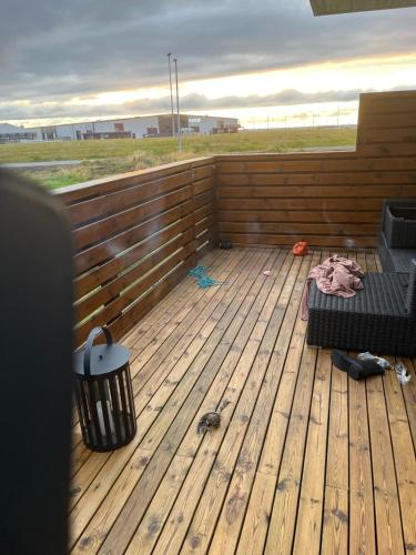 a wooden deck with a bench and a trash can at Kirjuvekkir8a in Hafnarfjörður