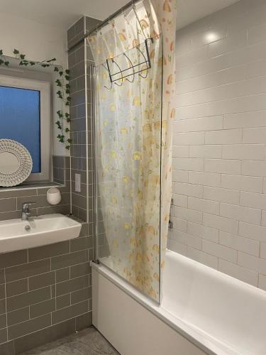 a bathroom with a shower curtain and a sink at Rendezvous in Romford