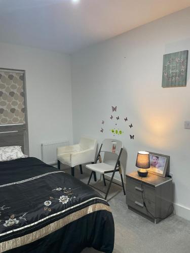 a bedroom with a bed and a table with a tv at Rendezvous in Romford
