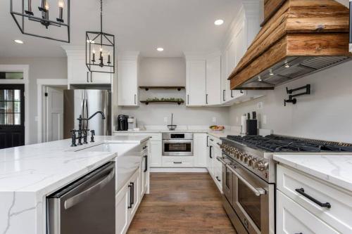 a kitchen with white cabinets and stainless steel appliances at Sunset Stay at 608 in Wormleysburg