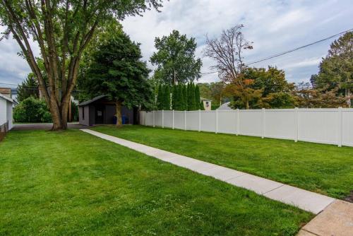 a white fence in a yard with a green lawn at Sunset Stay at 608 in Wormleysburg