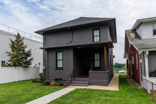 a black house with a front door and grass at Sunset Stay at 608 in Wormleysburg