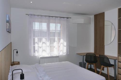 a bedroom with a bed and a table and a window at Propriété pour vous seul, vos amis et famille in Le Muy