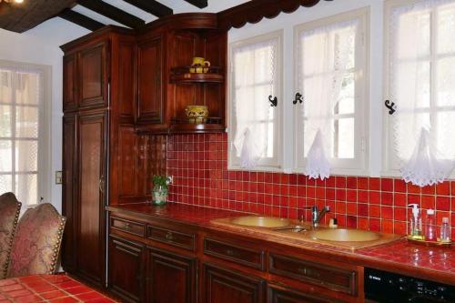 La salle de bains est pourvue de deux lavabos et de carrelage rouge. dans l'établissement Propriété pour vous seul, vos amis et famille, au Muy