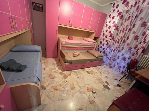 um quarto com 2 beliches e paredes cor-de-rosa em Casa Primavera em Mozzate